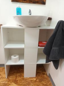 a white bathroom shelf with a sink on it at Chameleon Lodge in Cannonvale