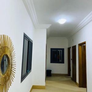 a hallway with a clock on the wall and a mirror at TérangaLux Appartement Le Yoruba Dakar Sacré Cœur 3 in Dakar