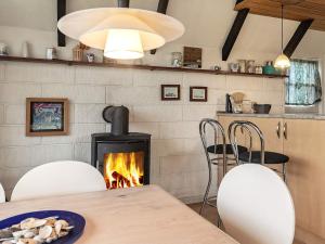 卜恩斯的住宿－6 person holiday home in Bogense，一间带壁炉和桌椅的用餐室