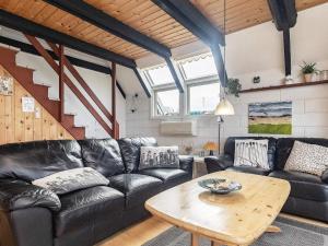 sala de estar con sofá de cuero y mesa en 6 person holiday home in Bogense en Bogense