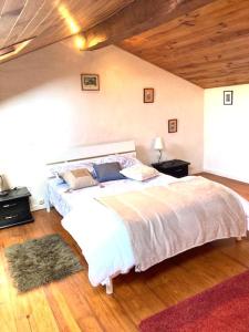 Villemur-sur-TarnにあるCocon paisible et confortable.の木製の天井が特徴のベッドルーム1室(大きな白いベッド1台付)