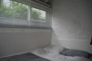 1 dormitorio con 1 cama y ventana con persianas en Rekerlanden 90 en Schoorldam
