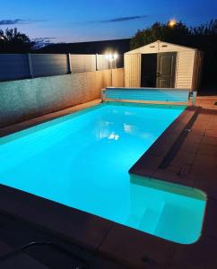 a swimming pool with blue lights in a backyard at La Villa de l'Olivier piscine privée et parking in Carcassonne