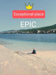 uma pessoa sentada numa praia perto da água em Epic em Selce