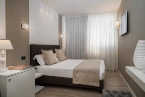 a hotel room with a bed and a window at Litoraneo Suite Hotel in Rimini