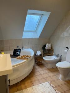 a bathroom with a tub and a toilet and a skylight at Fully Equipped Home Close to Malmö & Copenhagen in Vellinge