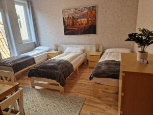 a room with three beds and a table and a window at Ferienwohnung im Tilly Boardinghouse in Hannoversch Münden