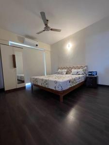 a bedroom with a bed and a ceiling fan at Home Office,Whitefield, ITPL in Bangalore