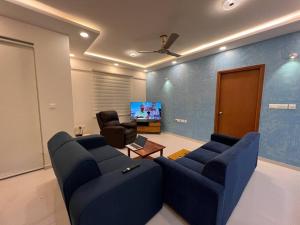 a living room with a blue couch and a chair at Home Office,Whitefield, ITPL in Bangalore