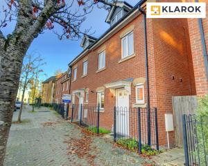 Un edificio de ladrillo con una puerta blanca en una calle. en LARGE 4 Bedroom Semi-Detached House Sleeps 7 By Klarok Short Lets & Serviced Accommodation, en Peterborough