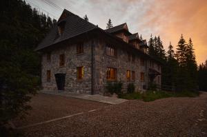 a large stone building in the middle of a forest at EnHotel in Zakopane