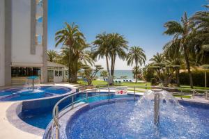 a swimming pool with a fountain in front of a resort at Gran Hotel Las Fuentes de Fantasía Hoteles in Alcossebre