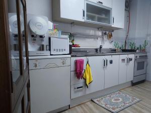 a small kitchen with white cabinets and a sink at J&J Guesthouse in Jeonju