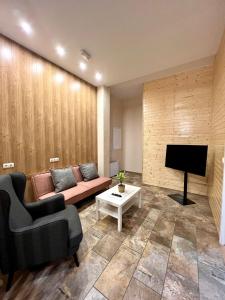 uma sala de estar com um sofá e uma televisão em Pasaje Apartamentos em Ronda