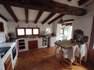 a kitchen with white appliances and a wooden table at La Rectoria de Dosquers 24p in Maia de Montcal