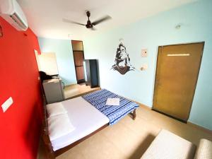 um quarto com uma cama e uma ventoinha de tecto em Morjim Guest House em Morjim