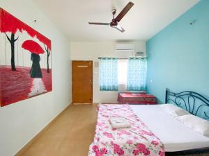 um quarto com uma cama e uma pintura de uma mulher com um guarda-chuva em Morjim Guest House em Morjim