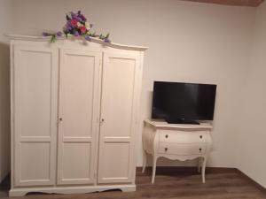 um armário branco com uma televisão em cima em Affittacamere Il Bastione 27 em Volterra