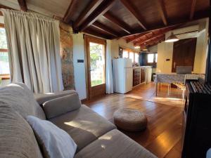 a living room with a couch and a kitchen at Casita con jacuzzi Rectoria de Dosquers in Maia de Montcal