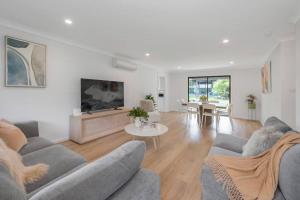 a living room with two couches and a table at Two Dreamy Properties In One in Culburra Beach