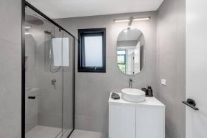a bathroom with a sink and a shower and a mirror at Two Dreamy Properties In One in Culburra Beach +15 photos