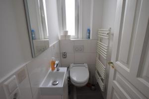 a white bathroom with a toilet and a sink at Wasen Apartment in Stuttgart