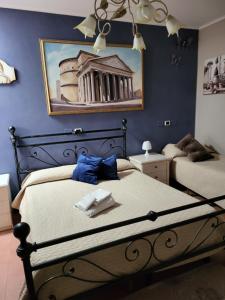 - une chambre avec 2 lits et un tableau mural dans l'établissement sole, à Rome