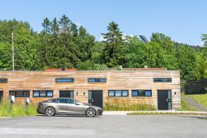 um carro estacionado em frente a um edifício de madeira em Topcamp Bogstad - Oslo em Oslo