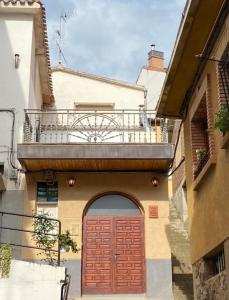 un edificio con puerta roja y balcón en Casa de pueblo con merendero y chimenea., en Viguera