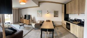 a living room with a couch and a table at Les 7 laux immobilier chalet F in Prapoutel