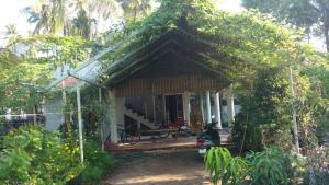 a small house with a porch and a motorcycle parked in front at Kalappura Homestay in Alleppey