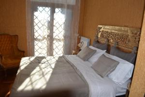 a bedroom with a white bed with a window at La casa di Tizio, Caio e Sempronio in Rome
