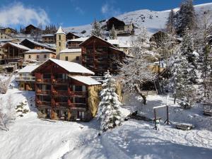 un lodge dans la neige avec des arbres enneigés dans l'établissement Les Chalets du Villard, à Saint-Véran