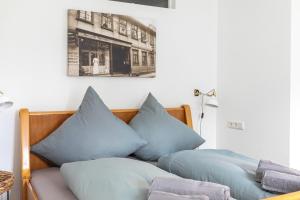 a bed with blue pillows on top of it at Hotel Alte Färberei in Goslar