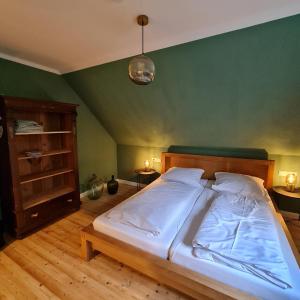 uma cama grande num quarto com uma parede verde em Ferienhaus Glücksgriff Pottenstein em Pottenstein