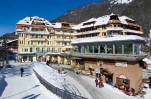 a large building with snow on top of it at Hotel Silberhorn - Residences & Spa Wengen in Wengen