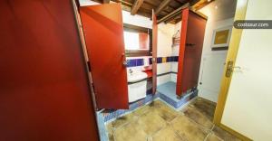 baño con puerta roja y lavamanos en La Majada en Ciudad-Rodrigo