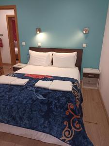 1 dormitorio con 1 cama grande y pared azul en Martim Moniz 28 Guest House, en Lisboa