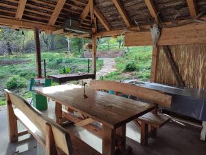 une grande table en bois et des bancs dans un pavillon dans l'établissement Balkan Retreat, à Bešenovo