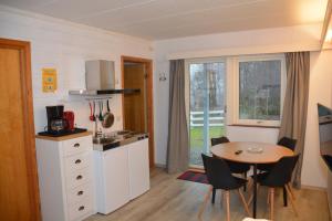 a kitchen and dining room with a table and a table and chairs at Langenuen Motel & Camping in Stord