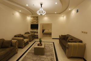 فندق حصن الأبلق - Alablaq Hotel في تيماء: غرفة معيشة كبيرة مع كنب وتلفزيون
