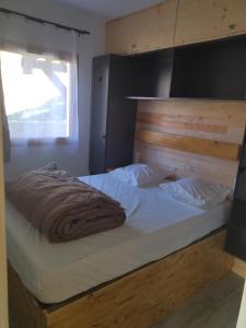 um quarto com uma cama grande e uma cabeceira em madeira em Appart terrasse Superdevoluy em Le Dévoluy