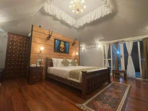 a bedroom with a bed and a chandelier at Nature Waterfall Resort, Bir in Chauntrā