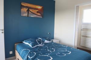 a blue bedroom with a bed with a blue wall at Ty Enez Mor in Lanildut