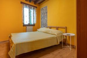 een gele slaapkamer met een bed en een tafel bij Stylish 2 bedroom with balcony in Verona