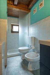 een badkamer met 2 toiletten, een wastafel en een bad bij Stylish 2 bedroom with balcony in Verona