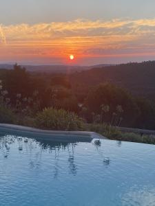 una piscina con puesta de sol en el fondo en Villa des Sapins en Peymeinade