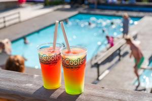 two drinks sitting on a table next to a swimming pool at Topcamp Rustberg - Hafjell in Hafjell