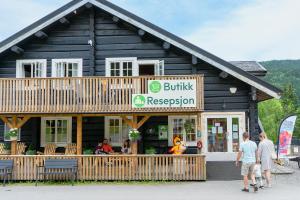 a building with people standing outside of a restaurant at Topcamp Rustberg - Hafjell in Hafjell