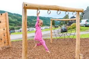 a little girl swinging on a swing at a playground at Topcamp Rustberg - Hafjell in Hafjell